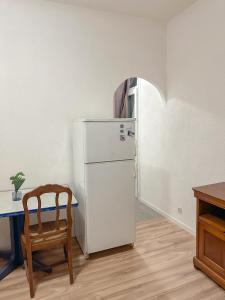 a kitchen with a refrigerator and a table and a chair at Votre Havre de Paix à Perpignan in Perpignan