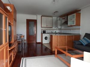 a living room with a couch and a kitchen at CASA MANUELA in Suances