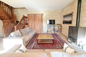 a living room with a couch and a fireplace at Belle demeure avec piscine à Bourgueuil 5 ch/10 p in Bourgueil