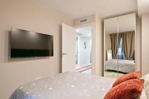 a bedroom with a flat screen tv on the wall at YOUR HOME- Apartment Camp Nou Baj in Hospitalet de Llobregat +12 photos