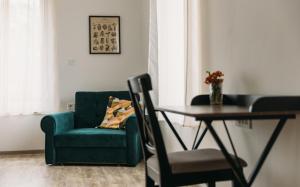 uma sala de estar com uma cadeira verde e uma mesa em Hiša na Ravnah em Pišece