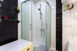 y baño con ducha y puerta de cristal. en Апартаменты возле метро Ботанический сад, en Járkov