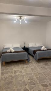 um quarto com 2 camas e uma ventoinha de tecto em Casa Centro By Lofts 48 em Querétaro