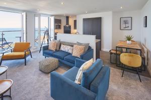 a living room with two blue couches and a table at Host & Stay - The Waves in Whitby +16 photos