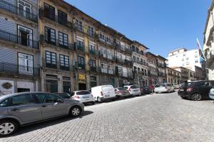 a row of cars parked on the side of a street at TAIPAS GUEST HOUSE in Porto