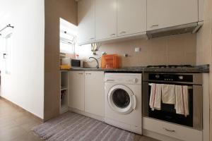a kitchen with a washer and dryer in it at Taipas Guest House in Porto