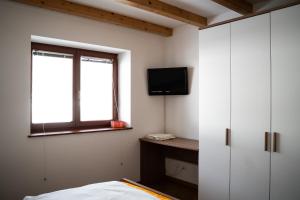 ein Schlafzimmer mit einem Bett und einem TV an der Wand in der Unterkunft Appartamento su due livelli 