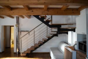 eine Wendeltreppe in einem Wohnzimmer mit Holzdecken in der Unterkunft Appartamento su due livelli 