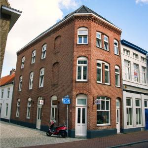 a brick building with a scooter parked in front of it at B&B De Hofnar Roermond in Roermond