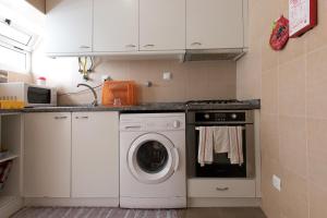 a kitchen with a washer and dryer at TAIPAS GUEST HOUSE in Porto