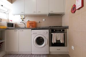 a kitchen with a washer and dryer at Taipas Guest House in Porto
