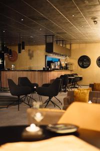 a restaurant with chairs and a bar in the background at Quality Hotel Grand Royal in Narvik