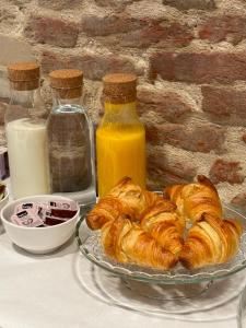 a table with a plate of pastries and bottles of milk at Faces & Places Boutique Hotel in Tirana