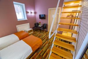 a room with a bed and a spiral staircase at Ukraina Hotel in Cherkasy