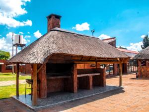 un pavillon avec un toit de paille dans une rue dans l'établissement Bokamoso Lodge and Conference Centre, 