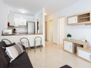 ein Wohnzimmer mit einem Sofa und einer Küche in der Unterkunft Live Caletillas Mencey in Candelaria