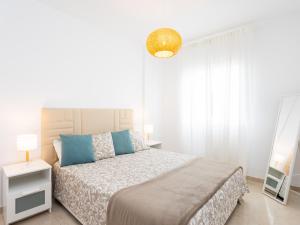 ein weißes Schlafzimmer mit einem Bett und einem Spiegel in der Unterkunft Live Caletillas Mencey in Candelaria