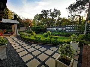 un jardín con un camino de piedra con plantas y una valla en Cozy Manor Guestrooms, en Lyttelton