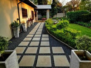 a garden with a stone walkway next to a house at Cozy Manor Guestrooms in Lyttelton