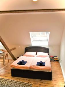 ein Schlafzimmer mit einem Bett mit zwei Hüten darauf in der Unterkunft Cityhouse Nauwies in Saarbrücken