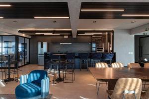 a large room with tables and chairs and a bar at Loft Marília City in Marília