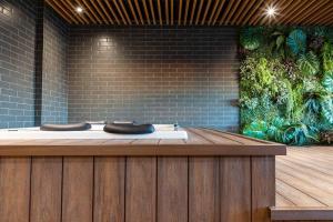 a wellness center with a wooden counter with two sparets at Loft Marília City in Marília