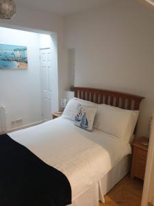 a bedroom with a white bed with two pillows on it at 1 bed self catering apartment in Weymouth