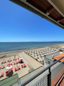 een uitzicht op een strand met stoelen en parasols bij Hotel Eden in Follonica