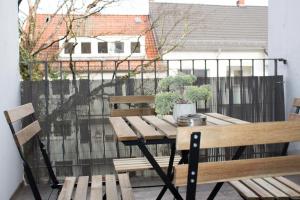 een houten tafel en stoelen op een balkon bij Timeless Apartment Bremen-Neustadt in Bremen