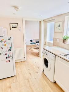 a kitchen with a refrigerator and a washing machine at Stylish City Centre House / 3 BR / Family Friendly in Belfast