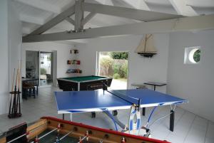 eine Tischtennisplatte in einem Wohnzimmer mit einer Tischtennisplatte in der Unterkunft Le Petit Bois in Sainte-Marie-de-Ré
