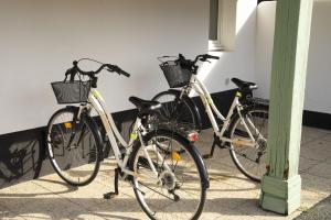 Dos bicicletas están estacionadas junto a una pared. en Le Petit Bois, en Sainte-Marie-de-Ré