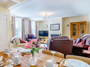 een woonkamer met een tafel en stoelen en een televisie bij 3 Bed in Cockermouth 59384 in Cockermouth