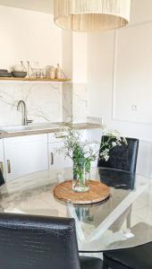a kitchen with a table with a vase of flowers on it at Terre de Bretagne, appartement entre port et plage in Audierne