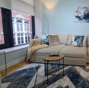 a living room with a couch and a table at Impressive Apartment at Leeds City Centre in Leeds