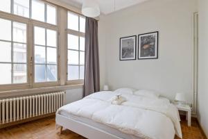 a white bedroom with a bed with a teddy bear on it at The Workspace w/Free Parking in Antwerp