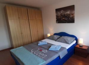 a bedroom with a blue bed with two towels on it at Turnic in Rijeka