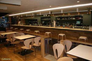 a restaurant with tables and chairs and a bar at APARTAMENTOS PICOS DE EUROPA in Santander