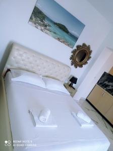 um quarto com uma cama branca e uma fotografia na parede em Amar Seaside em Ksamil