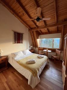 um quarto com uma cama e uma ventoinha de tecto em Buena Vida Social Club em El Bolsón