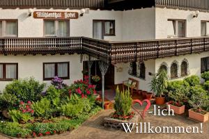 a building with a lot of plants and flowers at Hotel Mühlenthal GmbH in Schwalbach