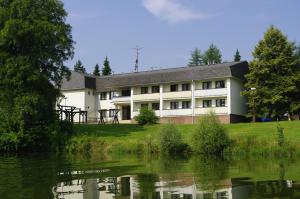 a building next to a body of water at Hotel Jaškovská Krčma in Horní Těrlicko