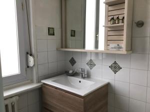 W łazience znajduje się umywalka i lustro. w obiekcie Logis Hôtel & Restaurant "Au Gré du Vent" w mieście Berck-sur-Mer