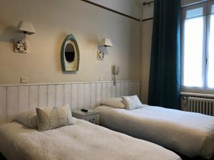 ベルク・シュル・メールにあるLogis Hôtel & Restaurant "Au Gré du Vent"の窓付きの客室で、ベッド2台が備わります。