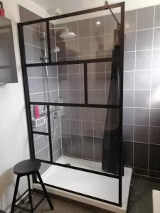 a glass shower with a stool in a bathroom at Phalemp'home in Phalempin