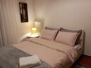 a bedroom with a large bed with a lamp on it at Citrus dream apartment in Athens