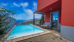 a house with a swimming pool next to a building at Villa Blue Marlin by LovelyStay in Calheta