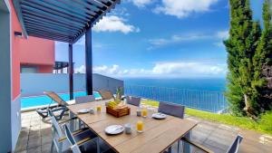 a table and chairs on a balcony with the ocean at Villa Blue Marlin by LovelyStay in Calheta