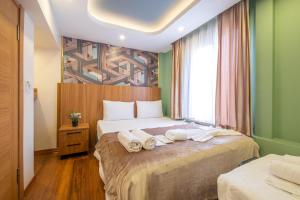 İstanbulites Hotel في إسطنبول: غرفة فندق عليها سرير وفوط