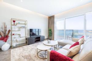 sala de estar con sofá y TV en Private Beach - 4BR - 8 Sleep - Pool - 180 grades Sea & Ain View - Huge Balcony - Parking - Prime Location, en Dubái